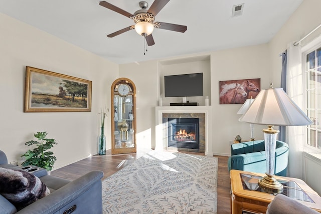 living room featuring dark hardwood / wood-style flooring, a fireplace, and ceiling fan