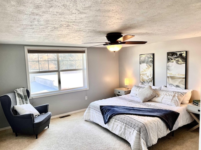 bedroom featuring carpet flooring, a textured ceiling, and ceiling fan