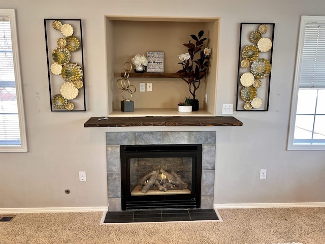 details with a tiled fireplace and carpet