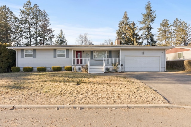 ranch-style house featuring a garage, covered porch, and a front lawn