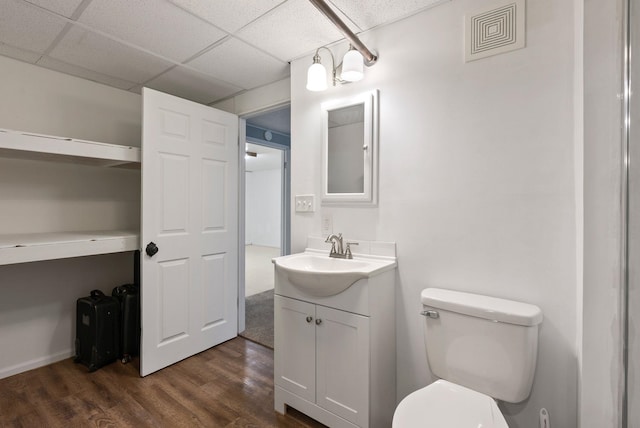 bathroom featuring a paneled ceiling, vanity, toilet, and wood-type flooring