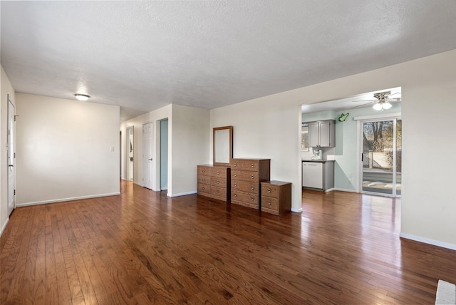 unfurnished living room with dark wood-type flooring, ceiling fan, and a textured ceiling