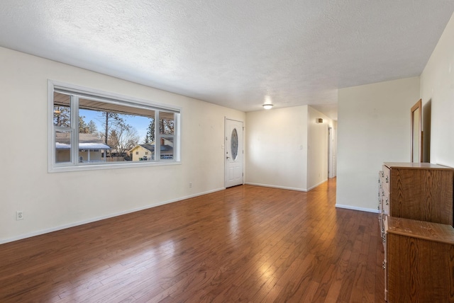 unfurnished living room with dark wood-type flooring and a textured ceiling