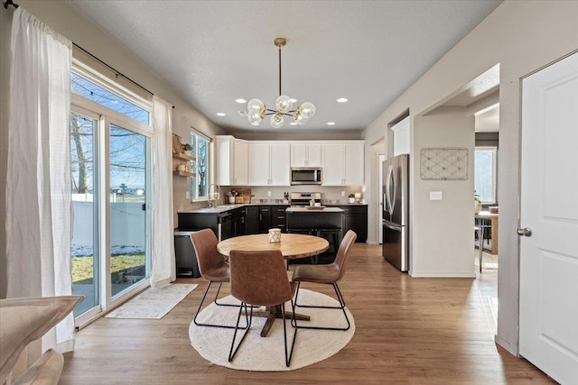 dining room with wood-type flooring, sink, and a wealth of natural light