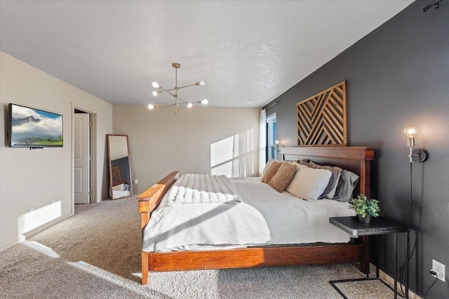 carpeted bedroom with a chandelier and a textured ceiling