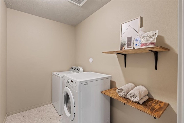 washroom featuring independent washer and dryer and a textured ceiling