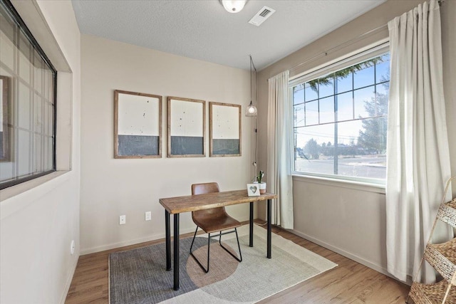 office with a textured ceiling and light hardwood / wood-style flooring