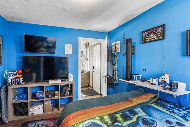 bedroom featuring wood-type flooring and a textured ceiling