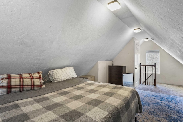 bedroom with vaulted ceiling, carpet floors, and a textured ceiling