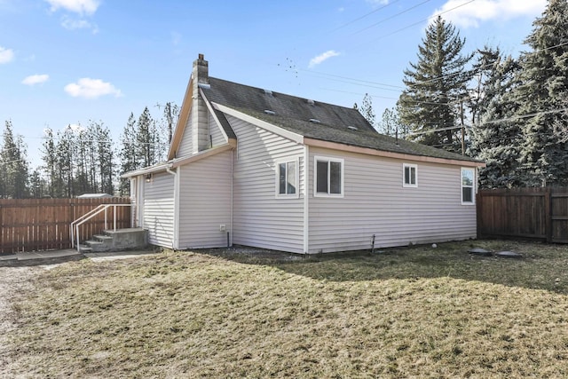 rear view of house featuring a lawn