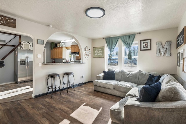 living room with dark hardwood / wood-style flooring and a textured ceiling