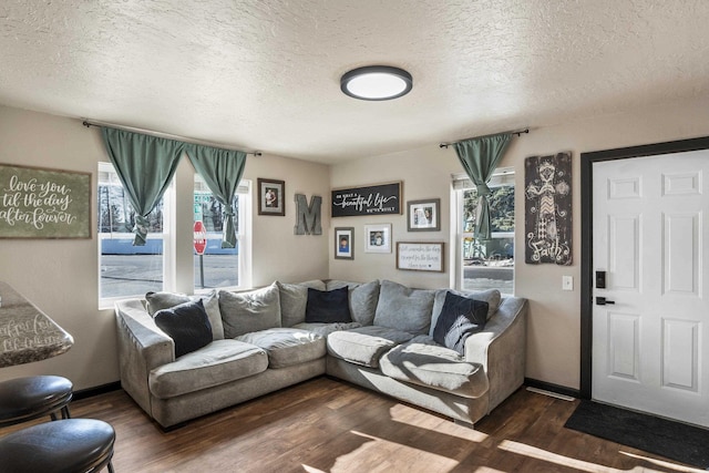 living room featuring a healthy amount of sunlight, dark hardwood / wood-style flooring, and a textured ceiling