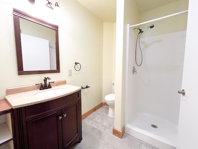 bathroom featuring tile patterned floors, vanity, toilet, and a shower