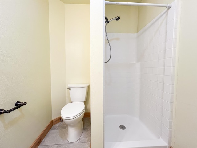 bathroom featuring tile patterned floors, toilet, and a shower