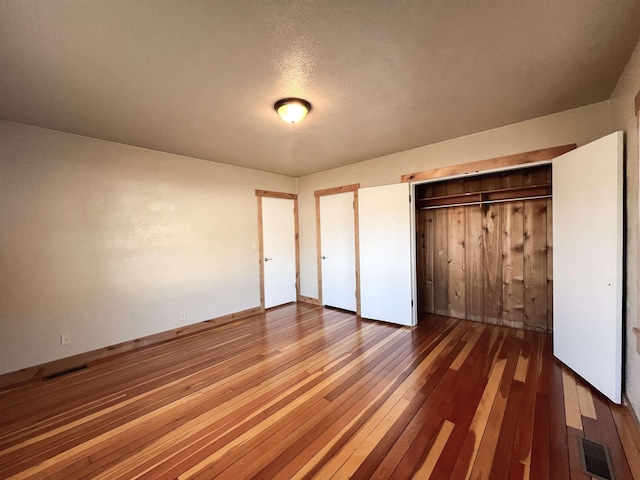 unfurnished bedroom featuring dark hardwood / wood-style flooring and a closet