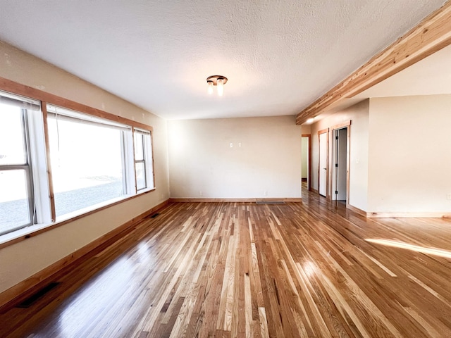 spare room featuring hardwood / wood-style flooring and a textured ceiling