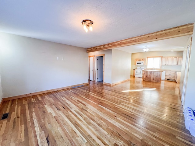 spare room with light hardwood / wood-style floors and a textured ceiling