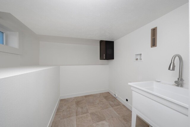 basement featuring dark carpet and a textured ceiling