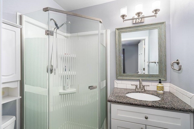 bathroom featuring toilet, vanity, and walk in shower