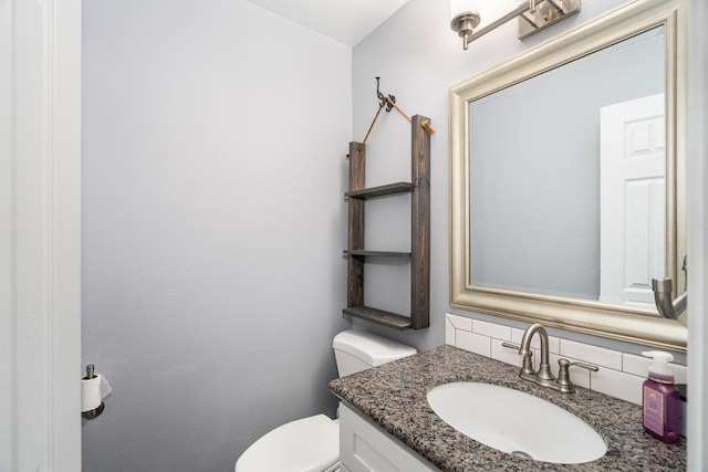 bathroom with tasteful backsplash, vanity, and toilet