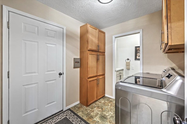 washroom featuring cabinets, washing machine and clothes dryer, and a textured ceiling