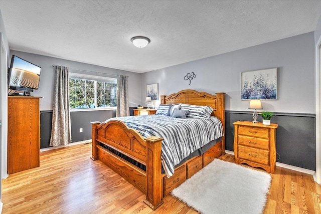 bedroom with a textured ceiling and light wood-type flooring