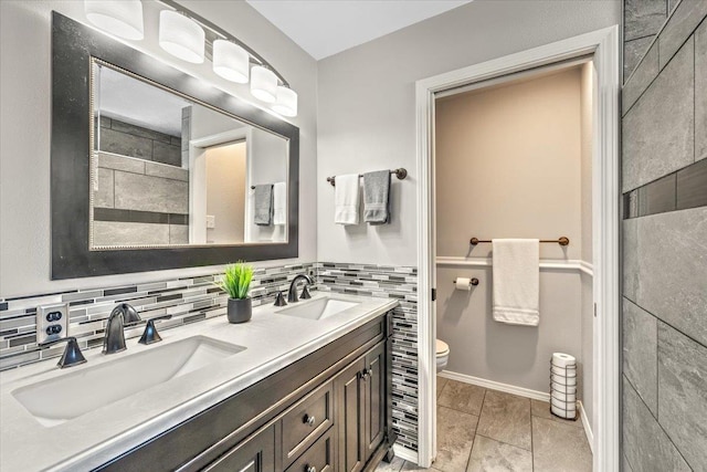 bathroom with tasteful backsplash, vanity, and toilet