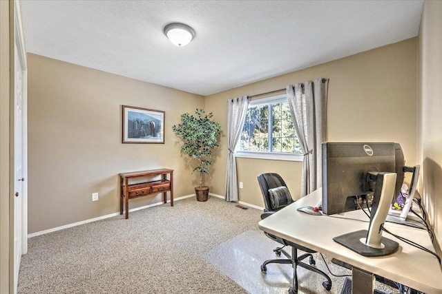 carpeted home office featuring a textured ceiling