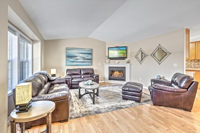 living room with light hardwood / wood-style floors and vaulted ceiling