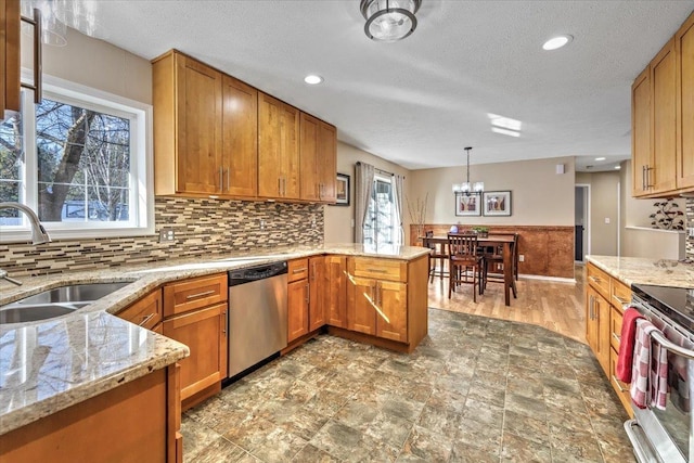 kitchen featuring sink, decorative light fixtures, a textured ceiling, kitchen peninsula, and stainless steel appliances