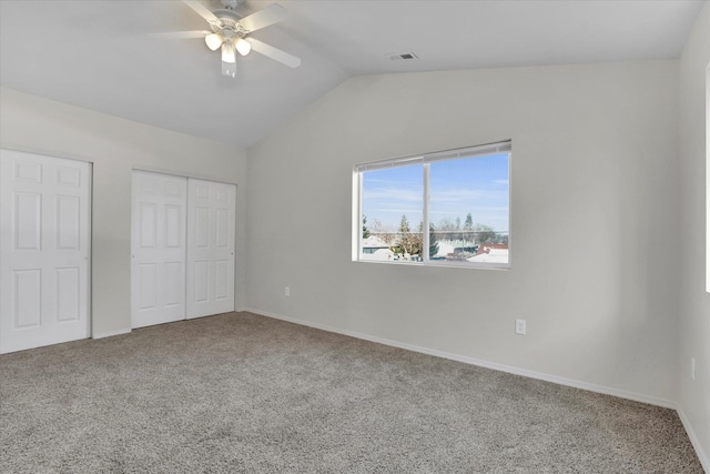 unfurnished bedroom featuring vaulted ceiling, a closet, ceiling fan, and carpet