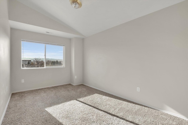 carpeted empty room with lofted ceiling