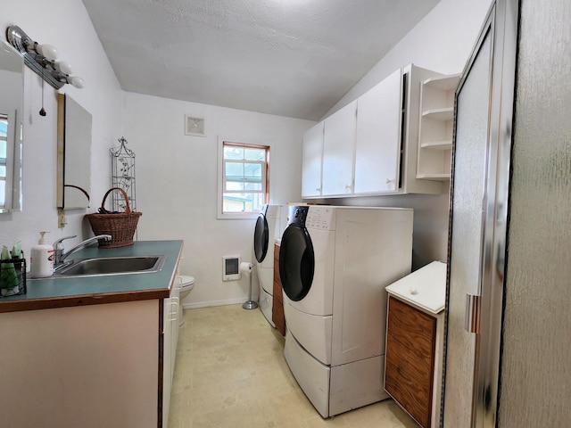 washroom featuring sink, heating unit, and washer and clothes dryer