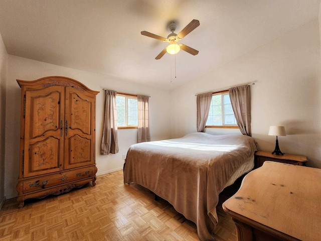 bedroom featuring ceiling fan, vaulted ceiling, multiple windows, and light parquet floors