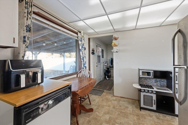 kitchen with white cabinetry, refrigerator, and white dishwasher