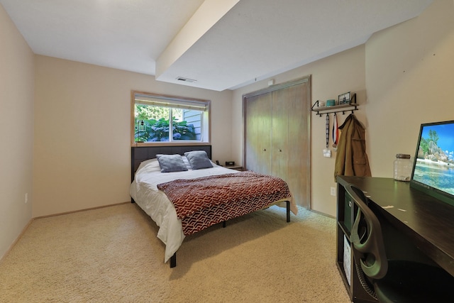 bedroom featuring light colored carpet and a closet