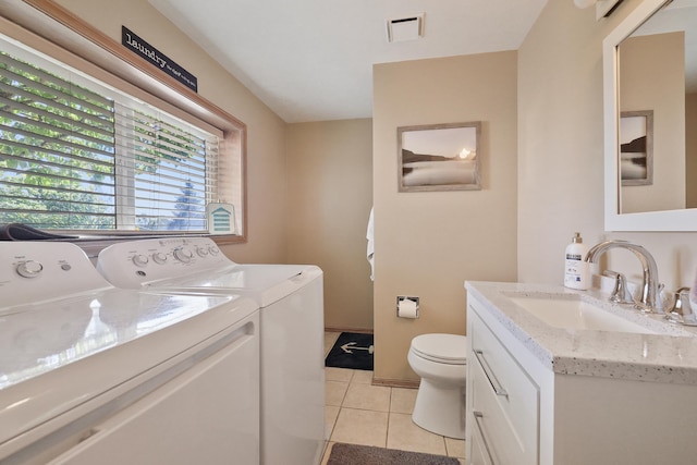 washroom with sink, washing machine and clothes dryer, and light tile patterned flooring