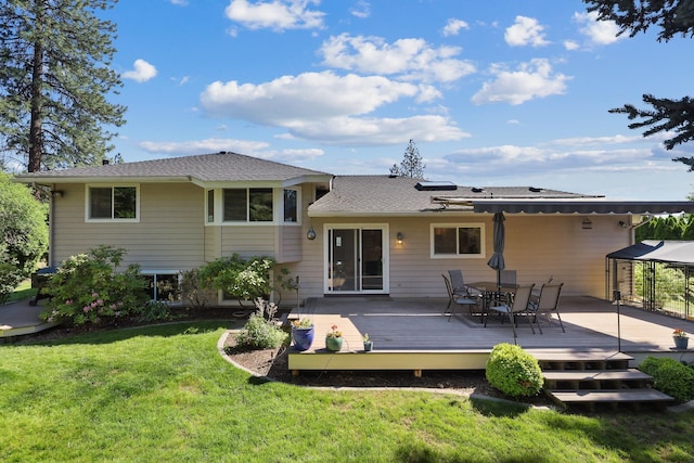 rear view of property with a yard and a deck