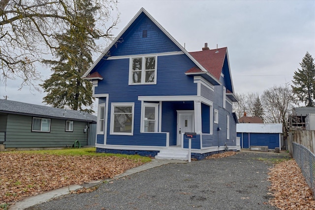 view of front facade featuring a garage and an outbuilding