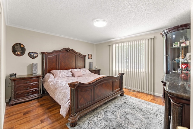 bedroom with dark wood-type flooring, ornamental molding, and a textured ceiling