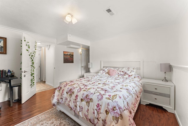 bedroom with crown molding and dark wood-type flooring