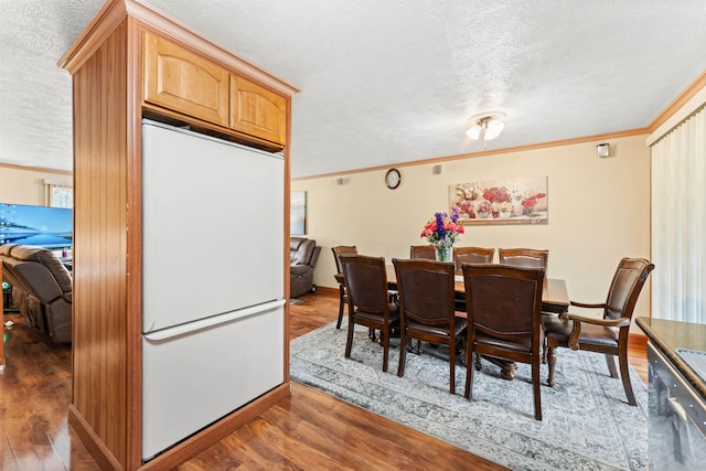 dining room featuring crown molding, dark wood-type flooring, and a textured ceiling