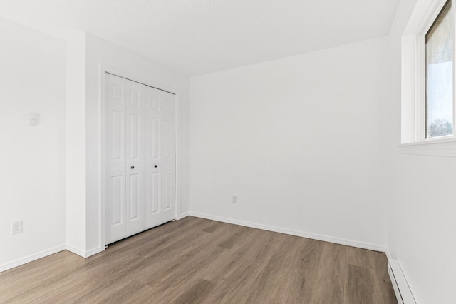 unfurnished bedroom featuring light hardwood / wood-style flooring and a closet