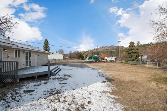 snowy yard featuring a wooden deck