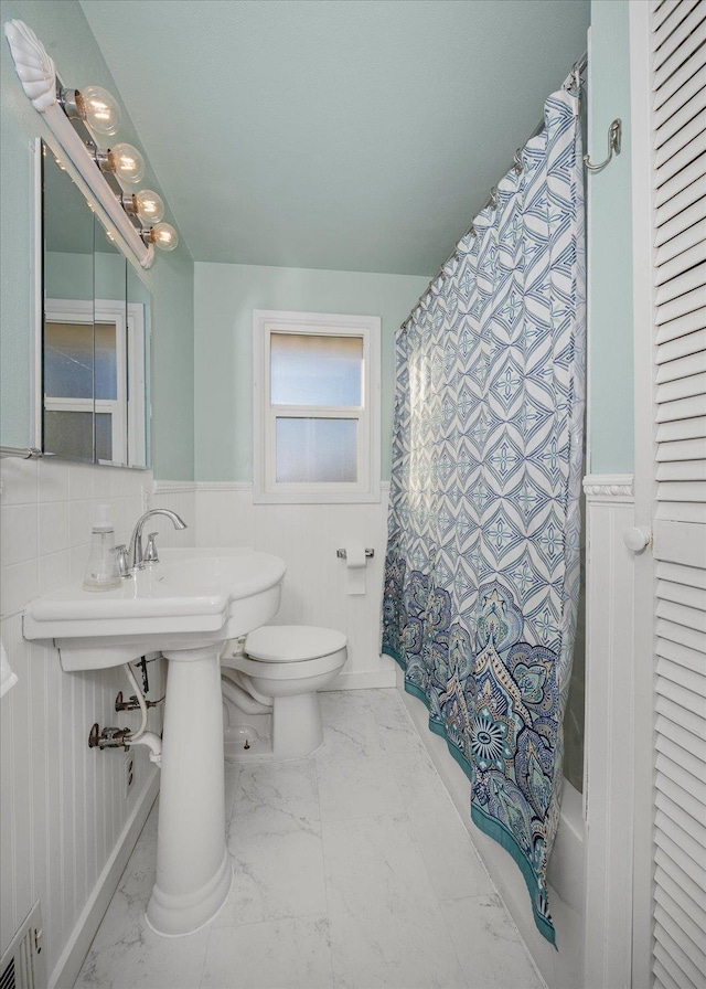 bathroom featuring shower / bath combo with shower curtain and toilet