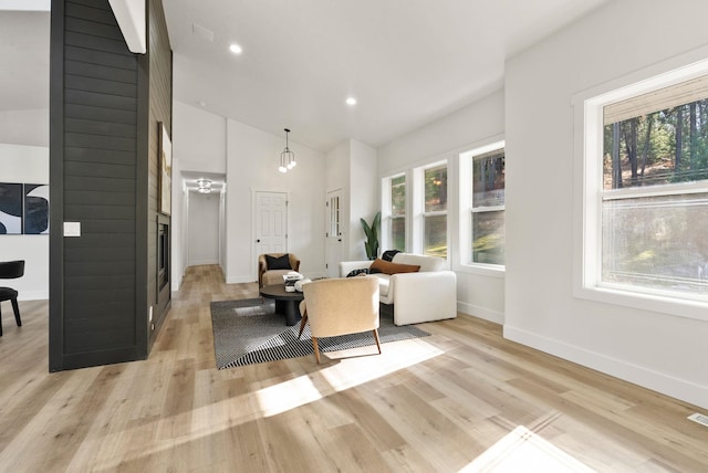 living room featuring high vaulted ceiling and light hardwood / wood-style floors