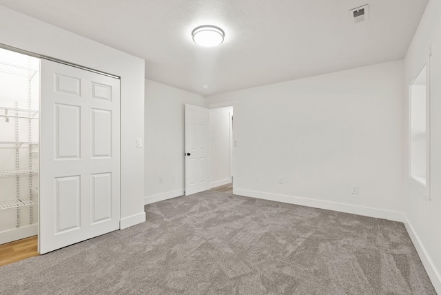 unfurnished bedroom featuring light carpet