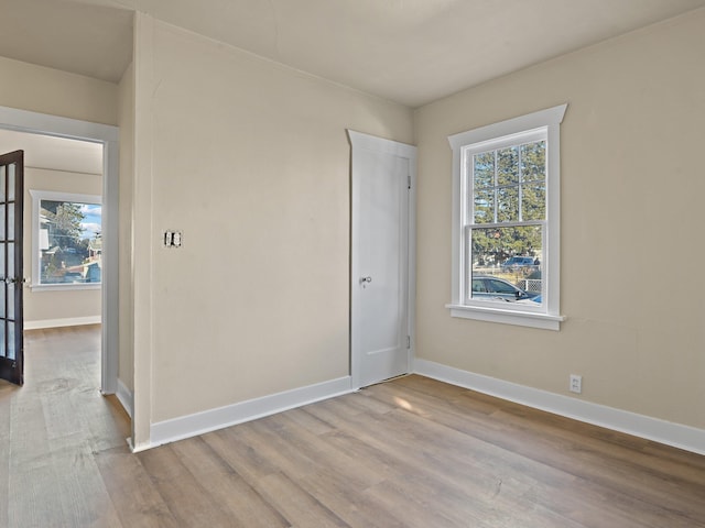 empty room featuring a healthy amount of sunlight and light hardwood / wood-style floors