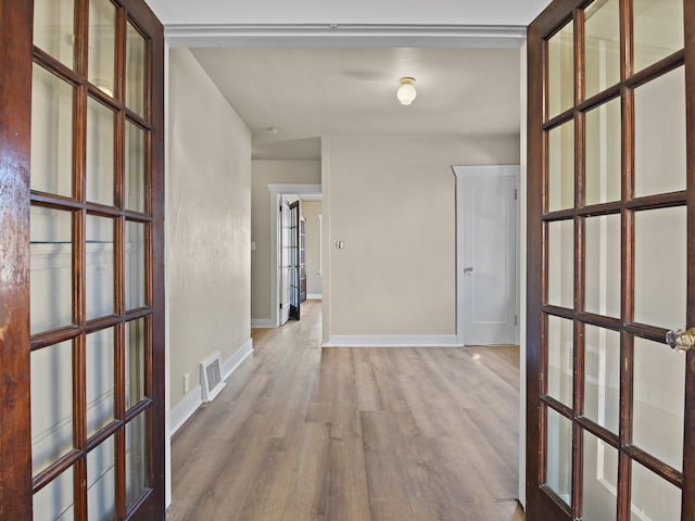 corridor featuring french doors and light hardwood / wood-style flooring