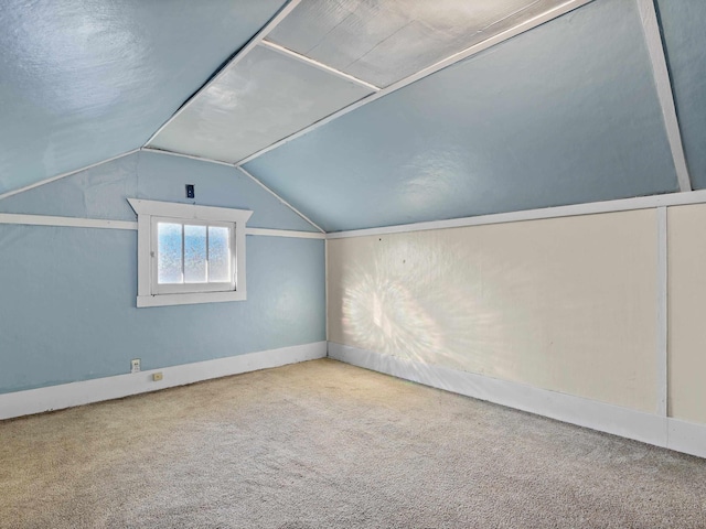 bonus room with vaulted ceiling and carpet flooring